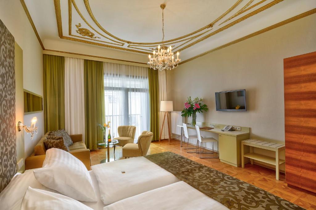 a hotel room with a large bed and a large window at Hotel Wandl in Vienna