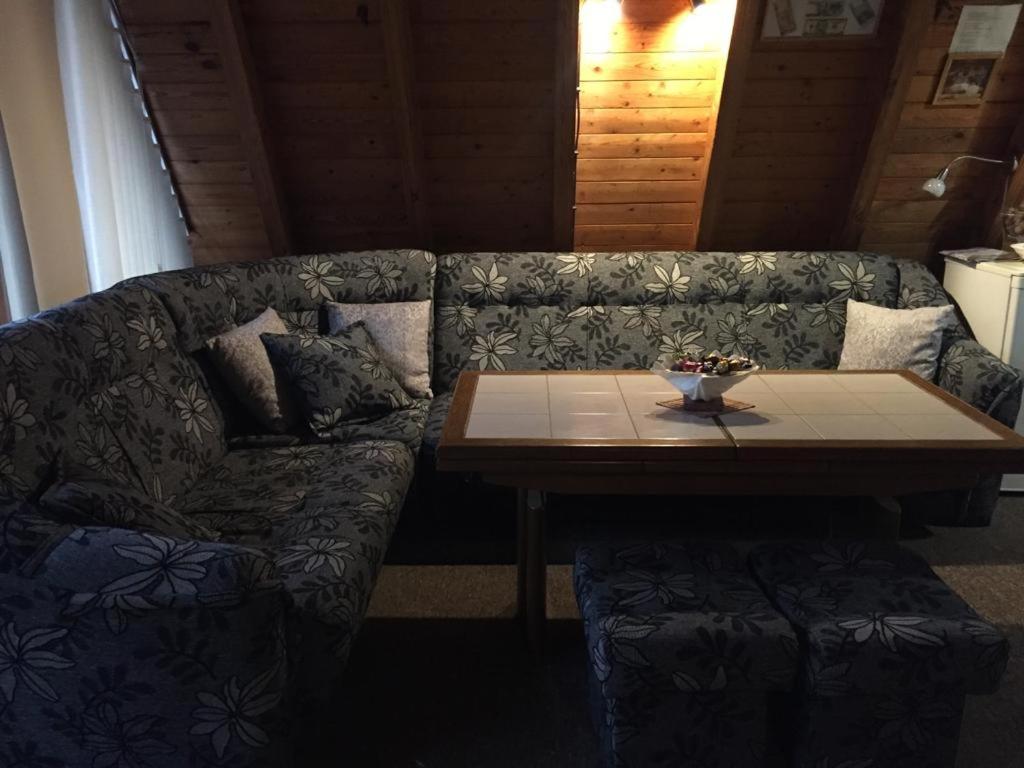 a living room with a couch and a wooden table at Domek Letniskowy in Mrzeżyno