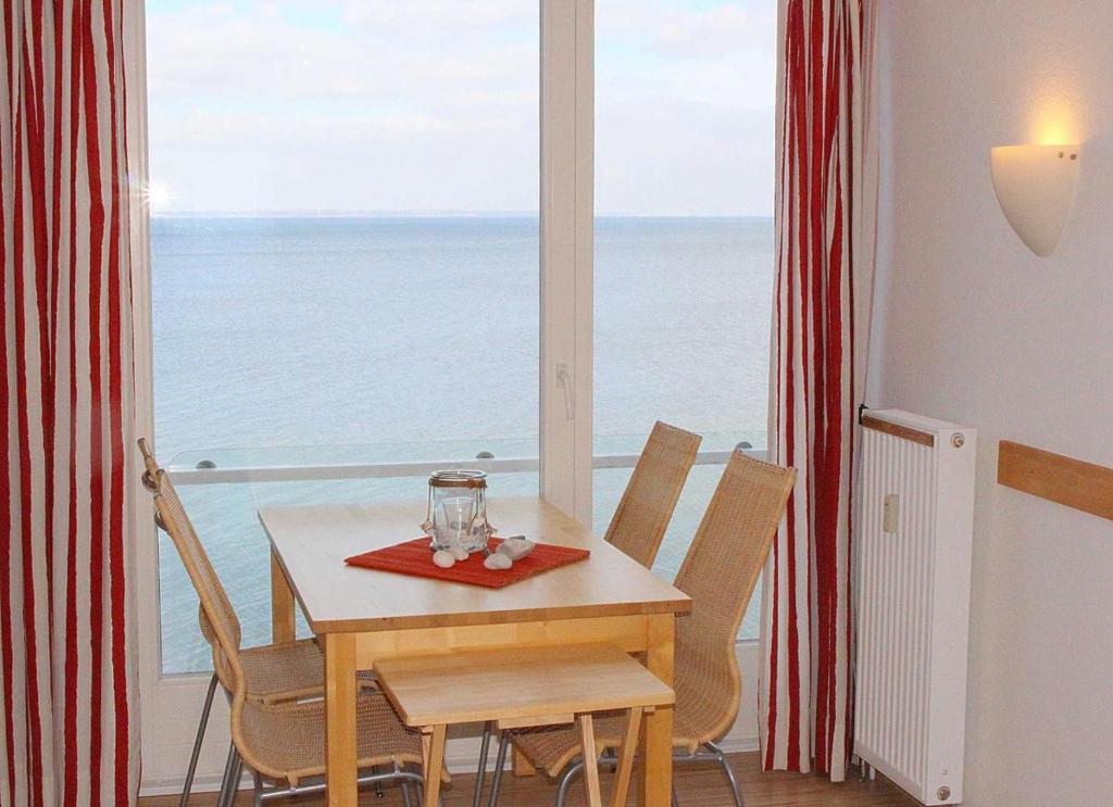 uma mesa e cadeiras com vista para o oceano em Apartmentvermittlung Mehr als Meer - Objekt 7 em Niendorf