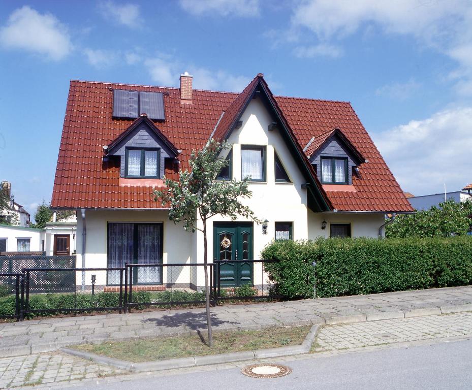 a white house with a red roof at Haus Arvert in Ostseebad Koserow