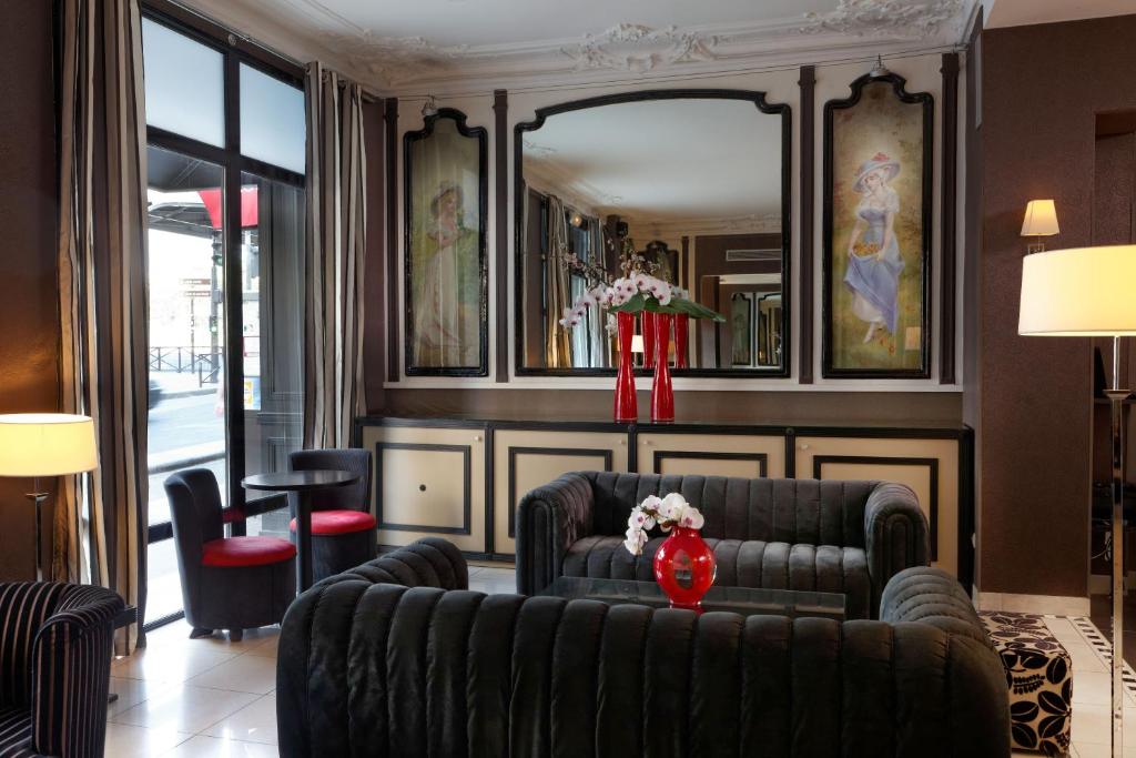 sala de estar con sofá y espejo en Hotel Eiffel Seine, en París