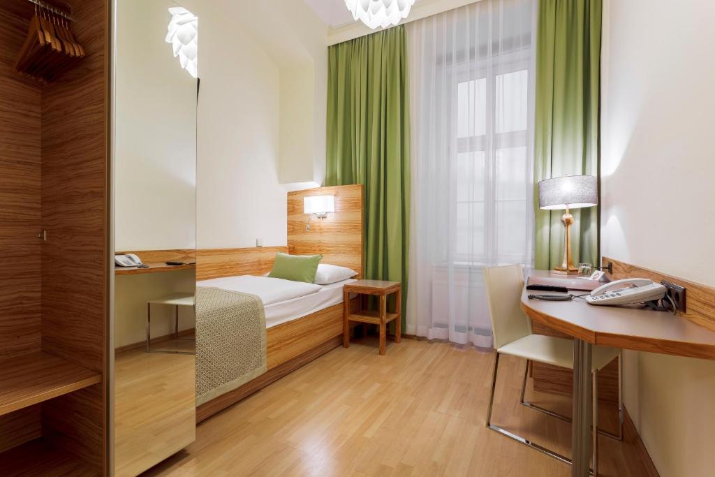 a hotel room with a bed and a desk at Hotel Wandl in Vienna