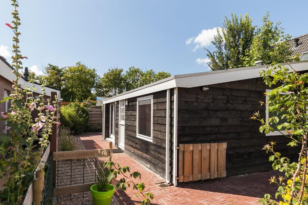 une maison noire avec un toit blanc dans l'établissement Huisje56, à Zoutelande