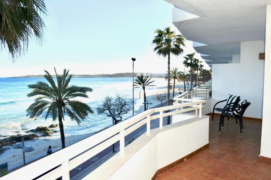 d'un balcon avec vue sur l'océan et les palmiers. dans l'établissement Meerblick Apartment Sabina, à Cala Millor