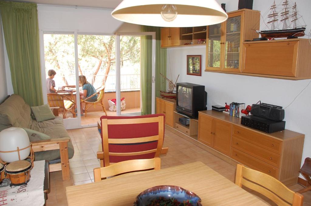 sala de estar con mesa y TV en Apartamento con ubicación inmejorable en Platja  d'Aro