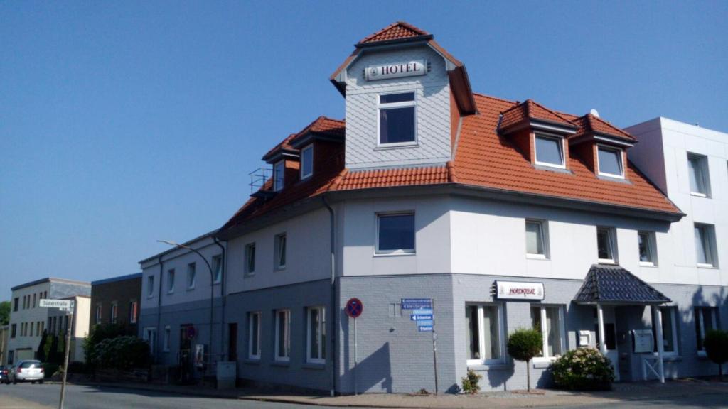 un edificio con techo naranja en una calle en Hotel am Nordkreuz, en Flensburg