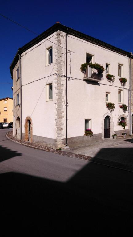 een wit gebouw met bloembakken op de ramen bij L'angolo fiorito in Castelpetroso