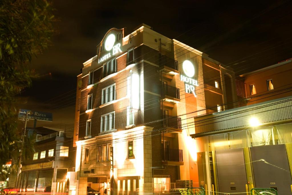 un edificio con un orologio sopra di esso di notte di Hotel Bintang Pari Resort (Adult Only) a Kobe