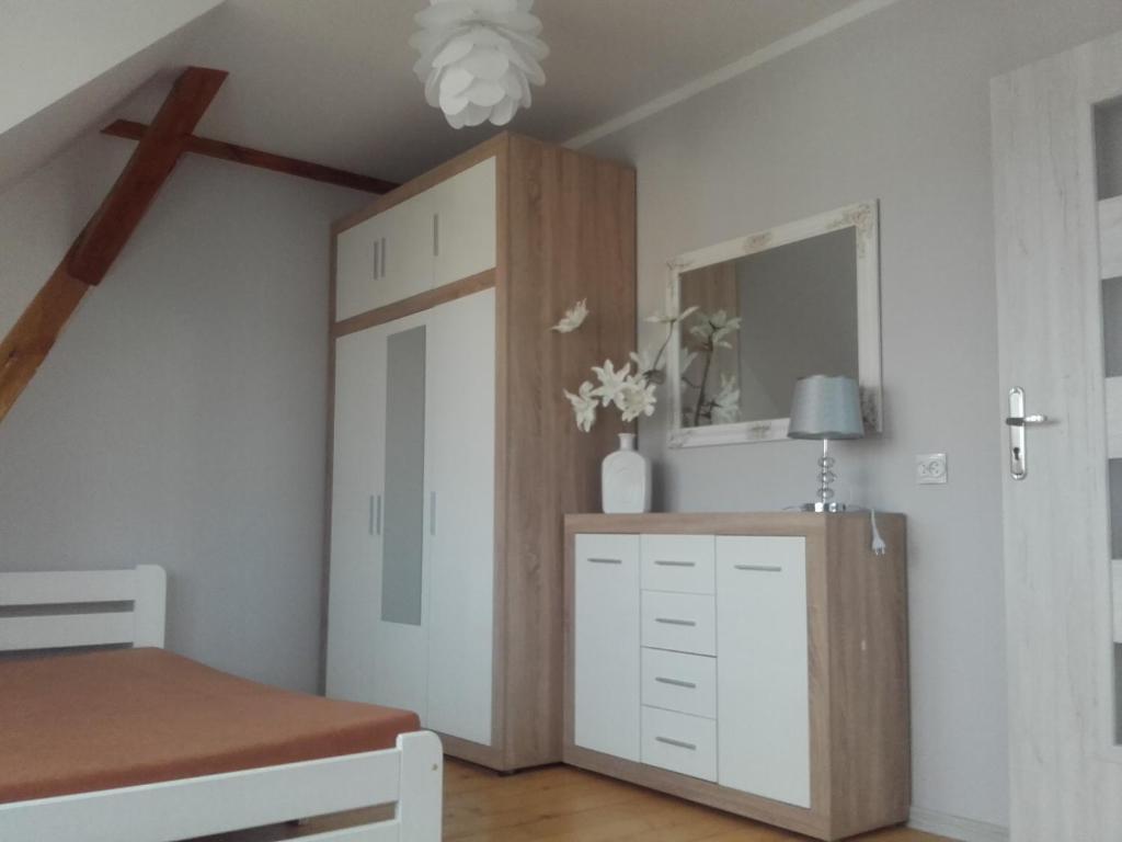 um quarto com uma cama e um armário com uma porta em Mazurskie Wzgórze 2 em Rydzewo