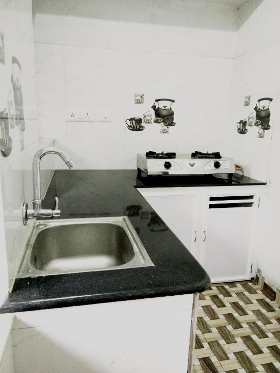 a kitchen with a sink and a stove at Nunu Homestay Guruvayoor in Guruvāyūr