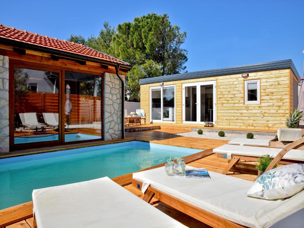 un patio trasero con piscina y una casa en Luxury mobile home Maro Biograd en Biograd na Moru
