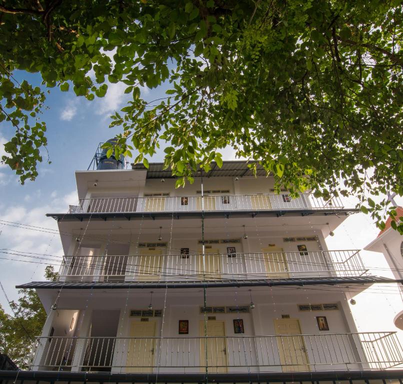a tall white building with balconies at Gems 9 Airport Hotel in Nedumbassery