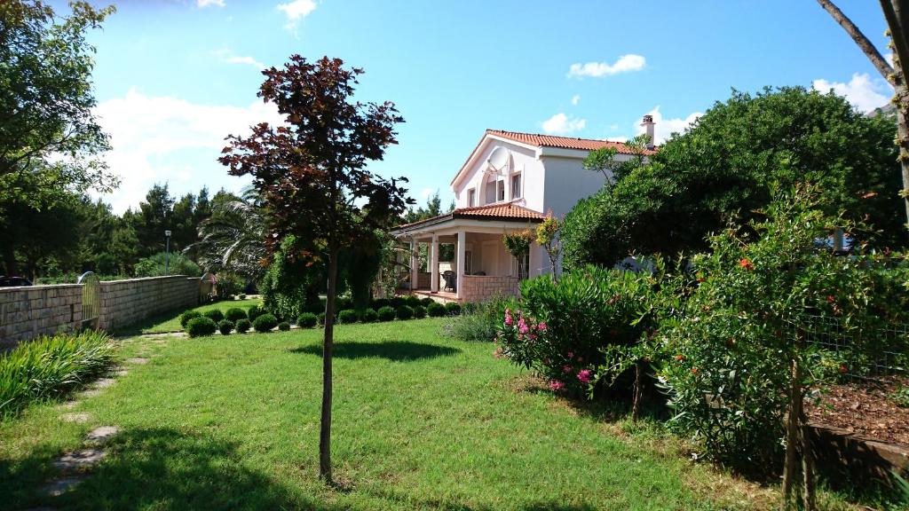 a house with a small tree in the yard at Apartments Villa Andreja in Starigrad