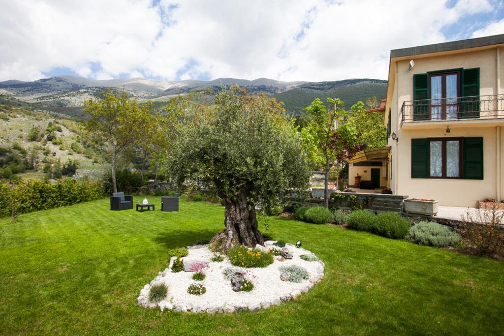 a tree in a garden in front of a house at B&B Al Colle in Pescosolido