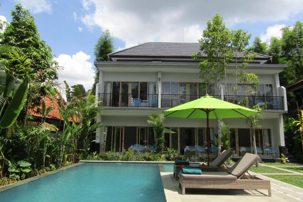 Casa con piscina y sombrilla verde en Recep Bungalow, en Ubud