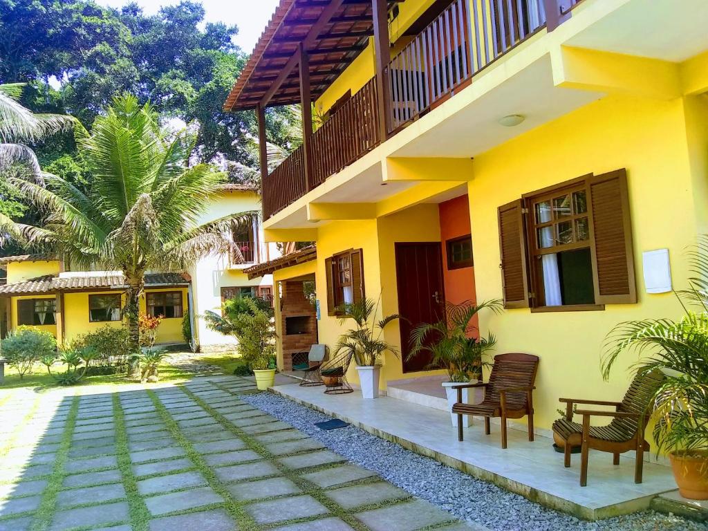 uma casa amarela com cadeiras e plantas em frente em Pousada Terra Boa em Paraty