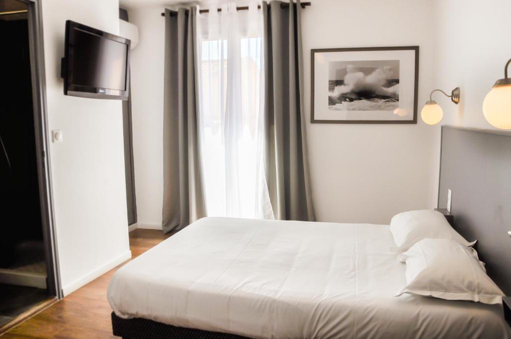 Postel nebo postele na pokoji v ubytování Hôtel les Arbousiers