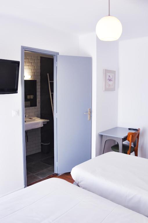 Postel nebo postele na pokoji v ubytování Hôtel les Arbousiers