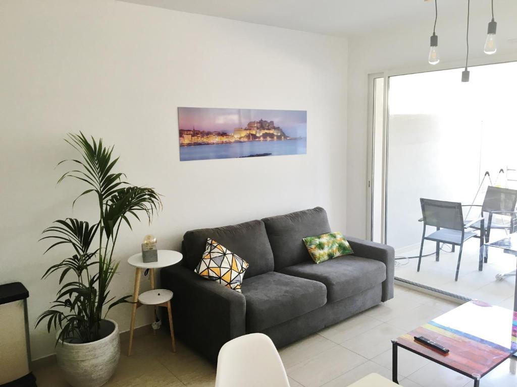 uma sala de estar com um sofá e uma mesa em CALVI em Calvi