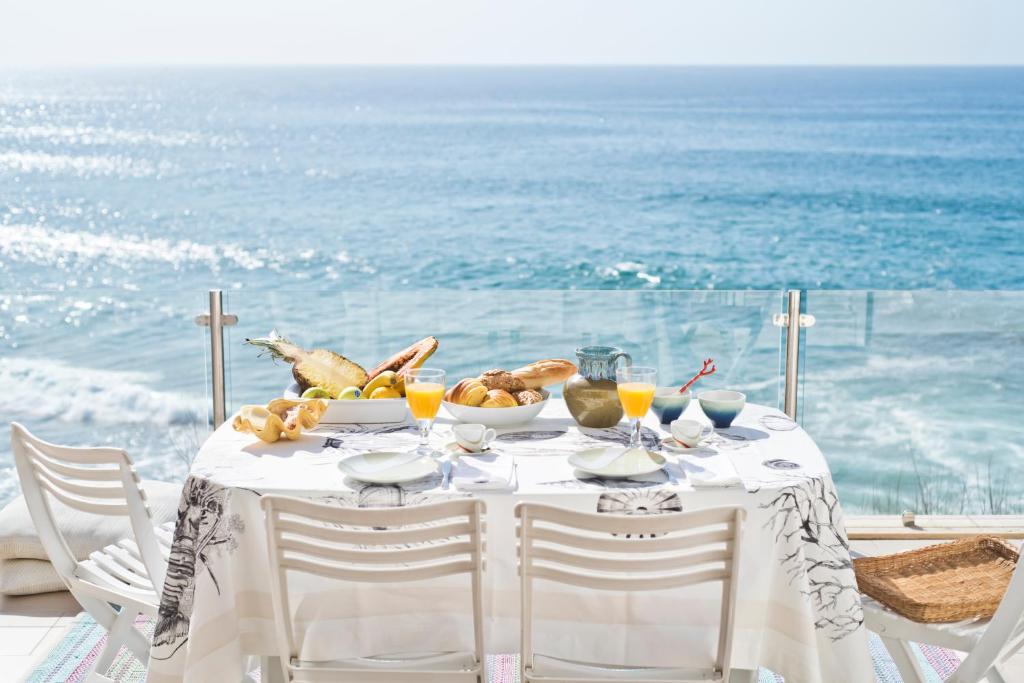 een tafel met een bord eten op de oceaan bij Cubo in Sintra