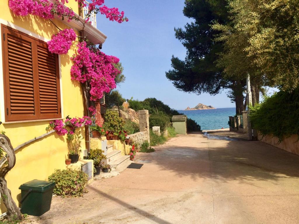 un bâtiment avec des fleurs sur le côté d'une rue dans l'établissement So close to the sea, à Santa Maria Navarrese