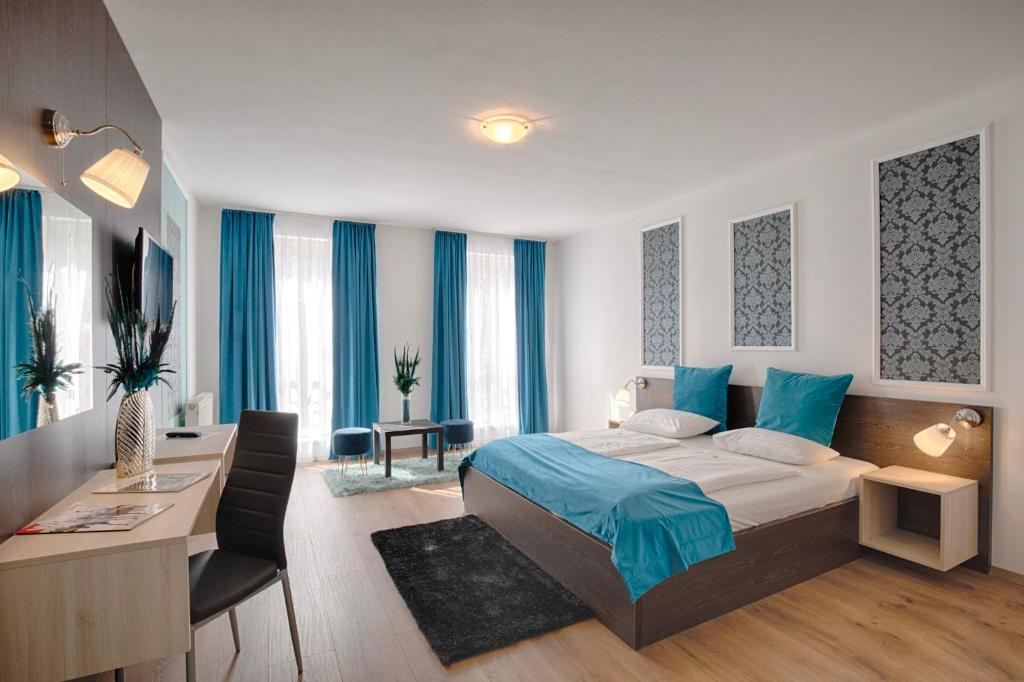 Habitación de hotel con cama, escritorio y escritorio. en Triple M Hotel, en Budapest
