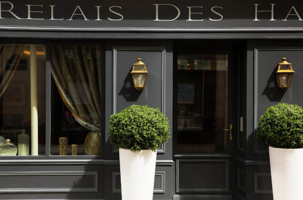 two potted plants in front of a store at Hôtel Le Relais des Halles in Paris