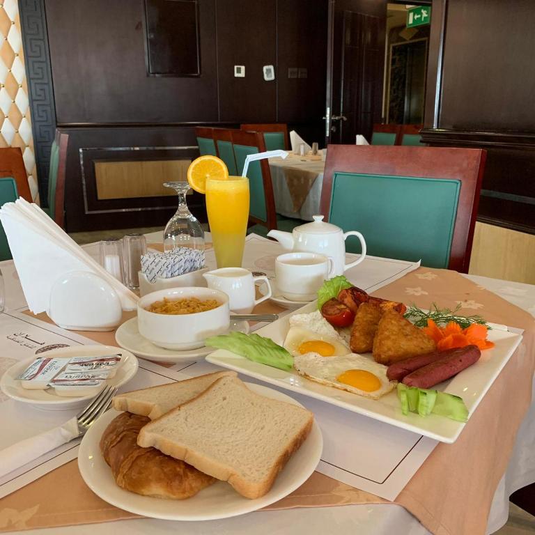 a table with a plate of breakfast food on it at Hala Inn Hotel Apartments - BAITHANS in Ajman 