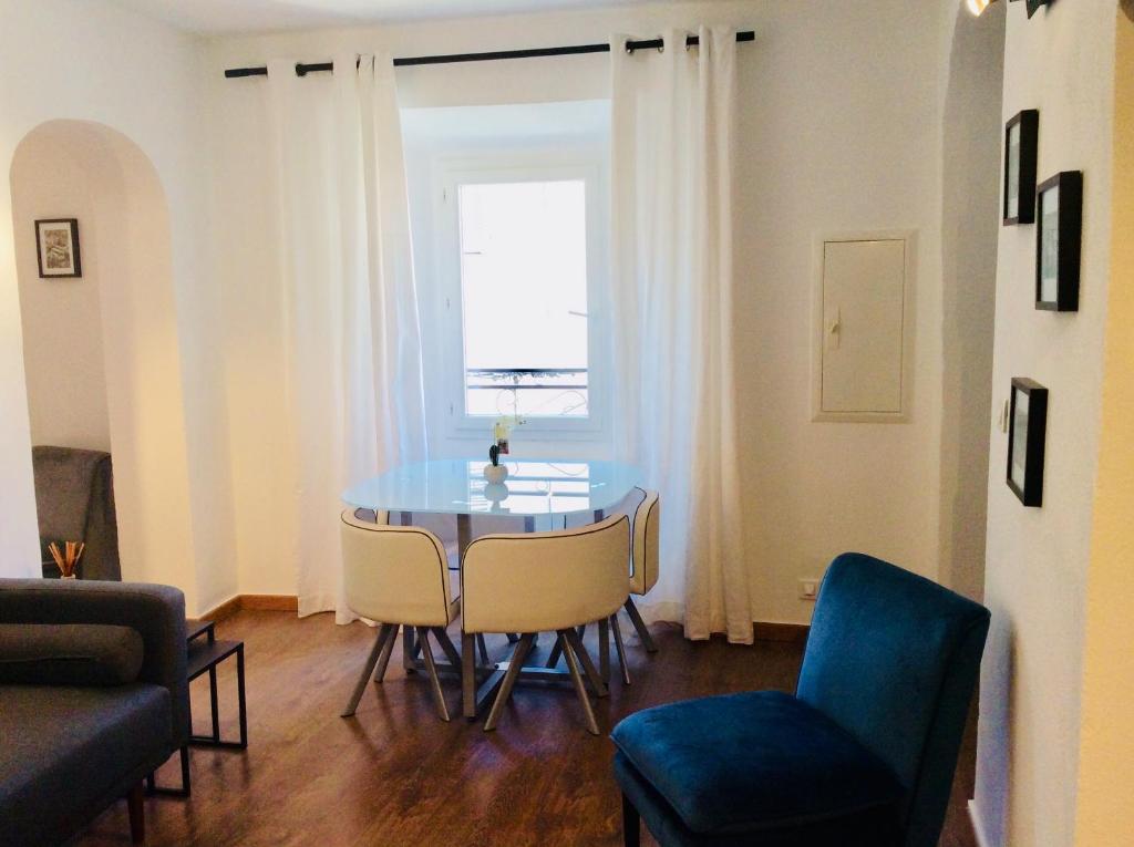 a living room with a table and chairs and a window at Appartement Doria in Saint-Florent