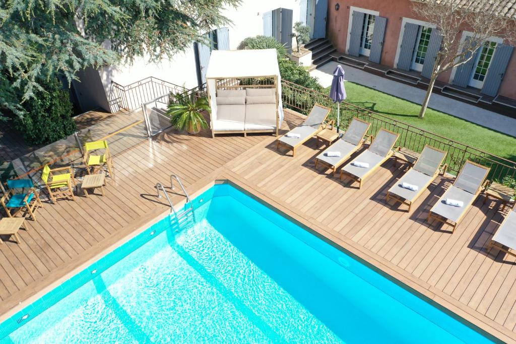 a swimming pool with chairs and a table at Les Jardins de Cassis in Cassis
