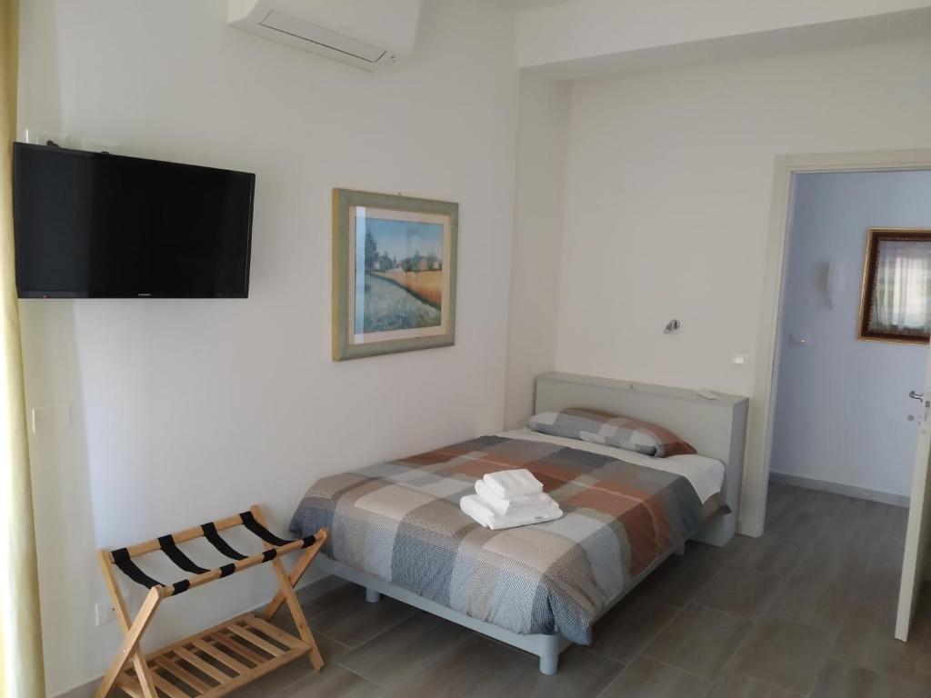 a bedroom with a bed and a flat screen tv at ARNO ROOMS VERONA in Verona