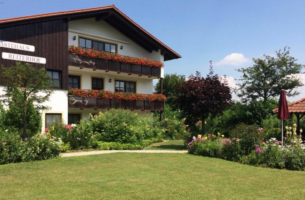 un bâtiment avec des fleurs sur son côté dans l'établissement Appartementhaus Reiterhof, à Bad Füssing