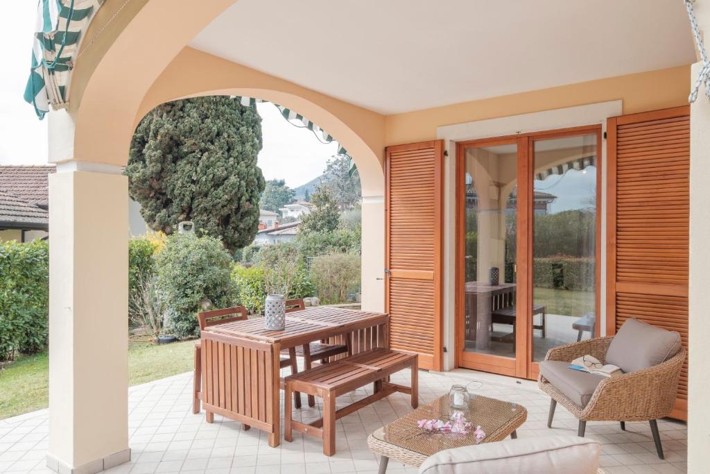 a patio with a table and chairs on a patio at Holiday House Ars in Gardone Riviera