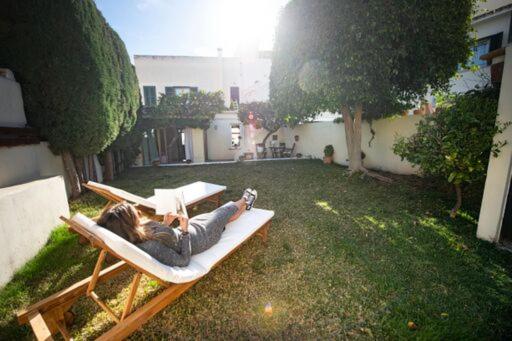 een vrouw op een hangmat in een tuin bij Casa en el barrio de Santa Catalina - Palma Aire Acondicionado de 2023 in Palma de Mallorca