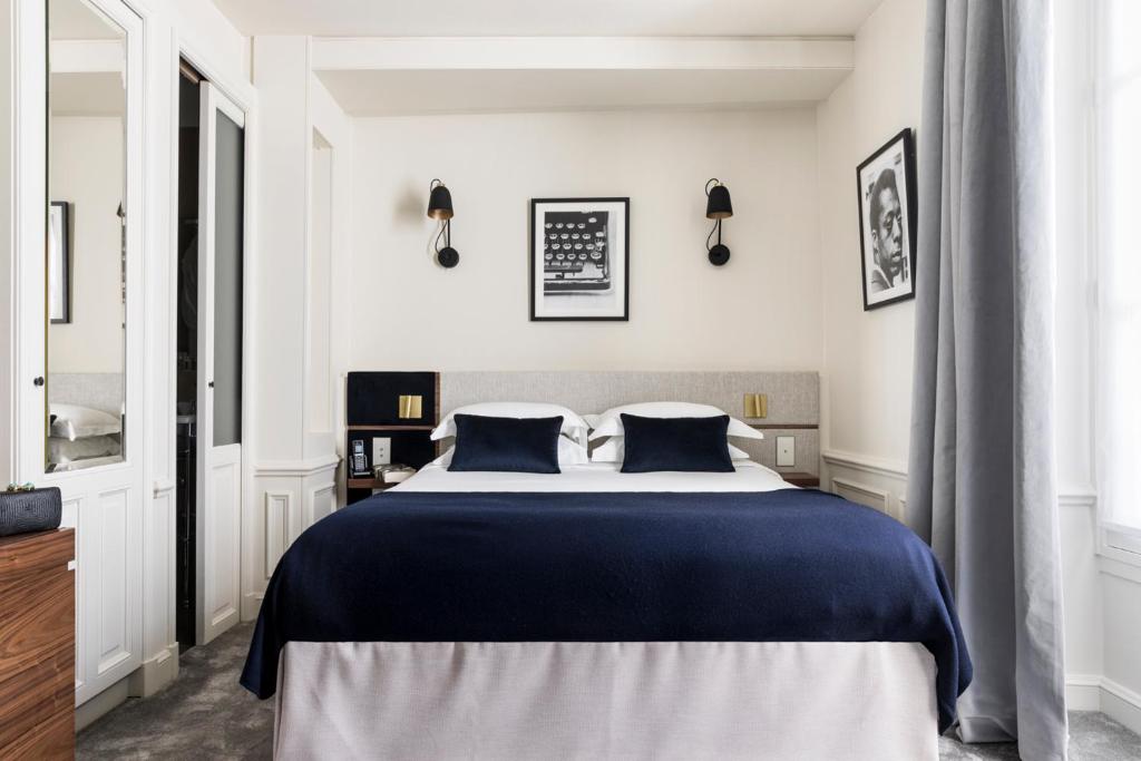 a bedroom with a large bed with blue sheets at Hotel Verneuil Saint Germain in Paris