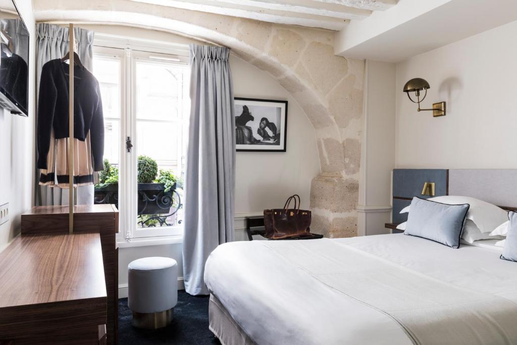 巴黎的住宿－沃穆爾聖日耳曼酒店，一间卧室设有一张大床和一个窗户。