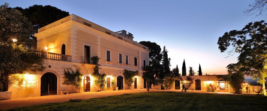 - un grand bâtiment blanc avec une cour la nuit dans l'établissement Cefalicchio B&B, à Canosa di Puglia