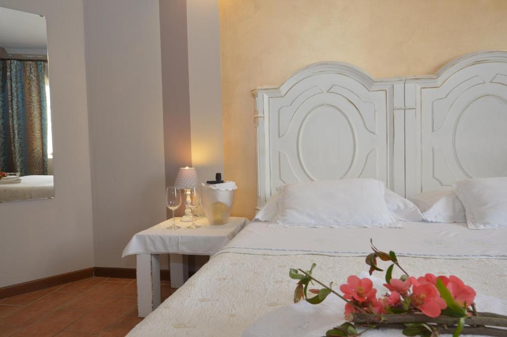 ブッソレンゴにあるGirelli Sorelleのベッドルーム(白いベッド1台、花のテーブル付)