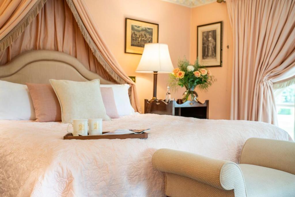 a bedroom with a large bed with two candles on a tray at Melbourne Lodge in Welwyn