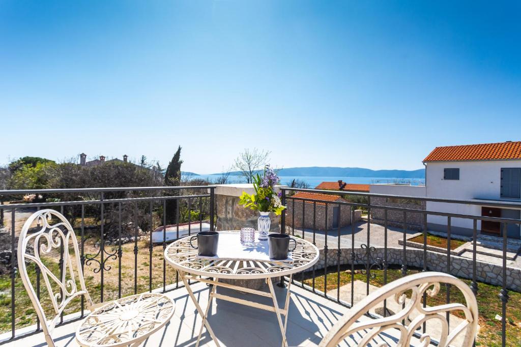 ピネジチにあるVilla Korinaのバルコニーにテーブルと椅子が置かれたパティオ