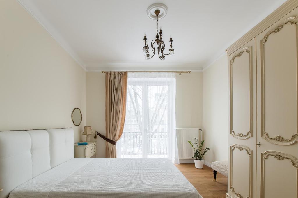een slaapkamer met een wit bed en een raam bij Apartment next to the Parliament in Vilnius