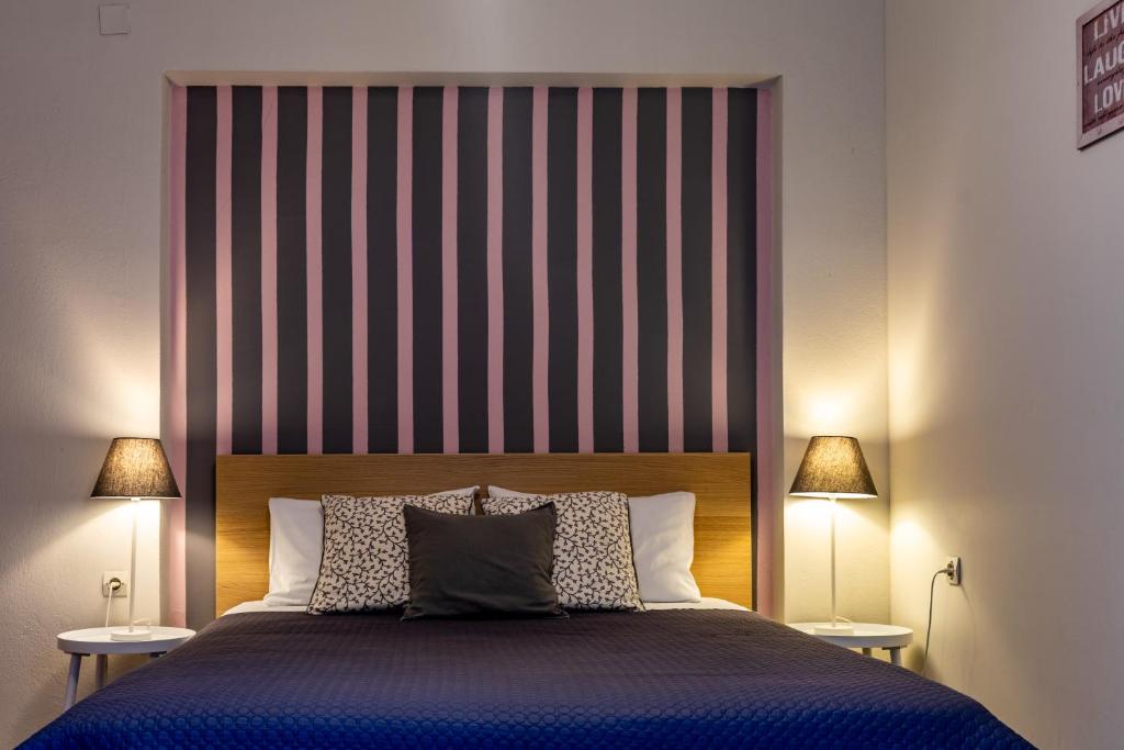 Anesi Rooms To Rent في أوليمبيا: غرفة نوم بسرير كبير و اللوح الأمامي مخطط