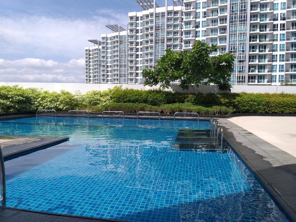 uma grande piscina azul com edifícios altos ao fundo em Mactan Newtown with Sun Set and Garden View em Cebu