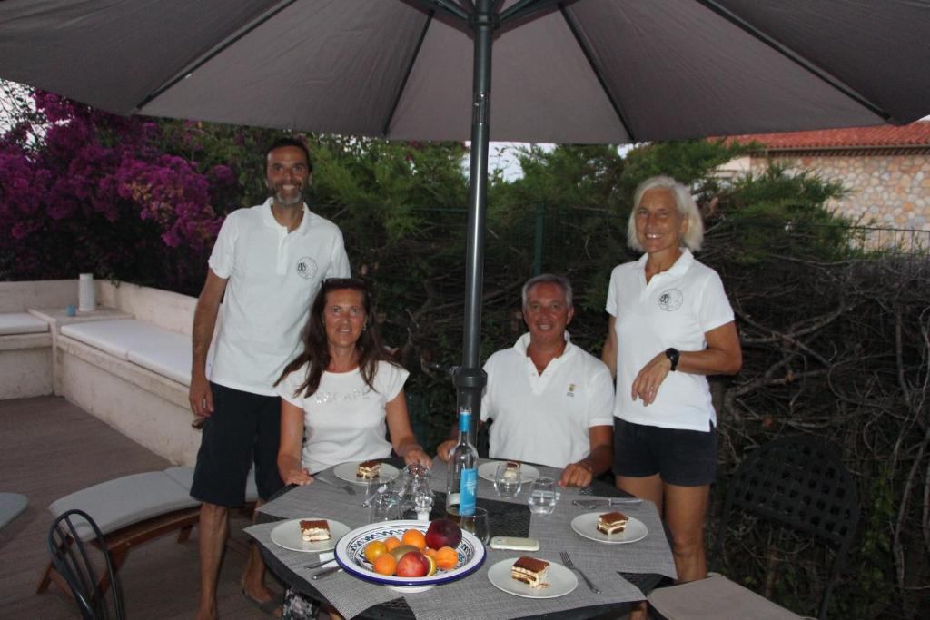 Un groupe de personnes autour d'une table avec un parapluie dans l'établissement B&B Bessy 10, à Antibes