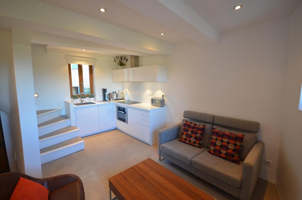 a living room with a couch and a kitchen at Ramatuelle Maison de Village in Ramatuelle