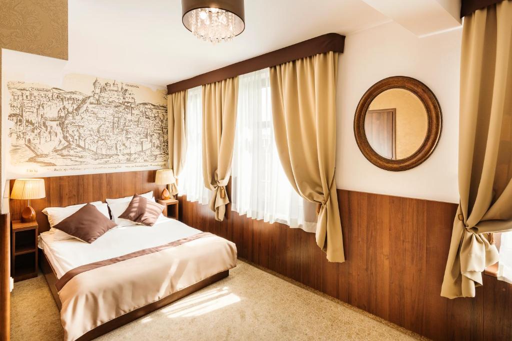 1 dormitorio con cama y espejo en David Boutique Hotel, en Cracovia