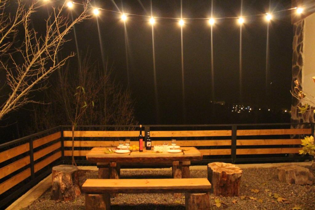 a picnic table with lights on a fence at night at Guest House on Meskheti in Borjomi