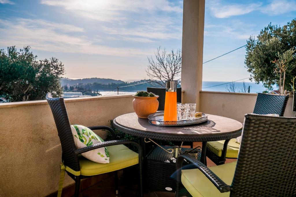 a table and chairs on a balcony with a view of the ocean at Maja Apartment Cavtat II in Cavtat