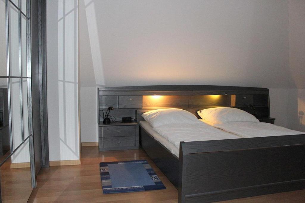 a bedroom with a large bed with a wooden headboard at Apartmentvermittlung Mehr als Meer - Objekt 54 in Niendorf
