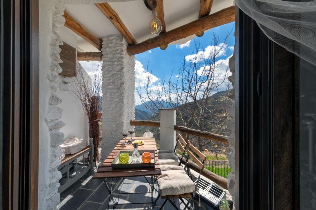 a balcony with a table with a bowl of fruit on it at El Rincón in Capileira